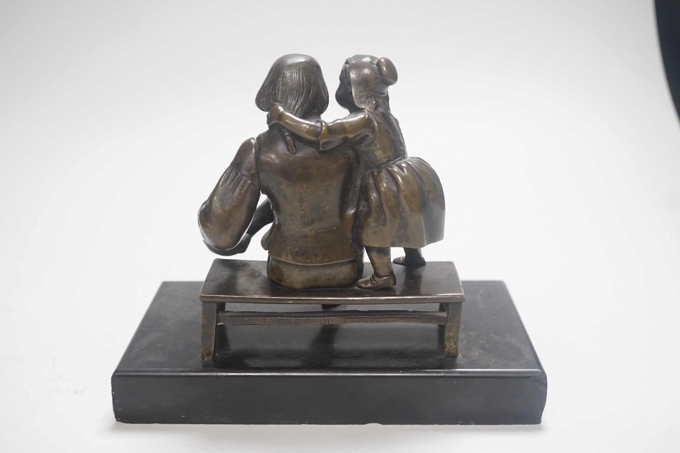 A 19th century bronze group of a gentleman smoking a pipe and a girl, on slate base 18.5cm wide